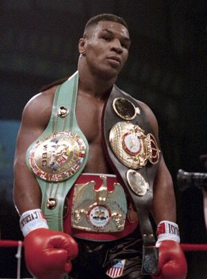 a man standing next to each other in a ring with two belts around his waist