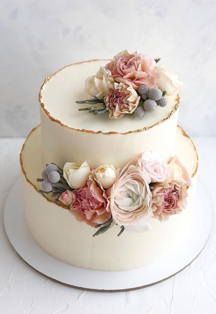 two tiered wedding cake with flowers on top