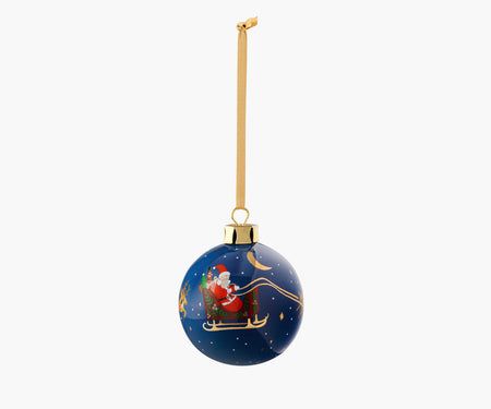 a blue christmas ornament with santa on a sleigh flying through the sky