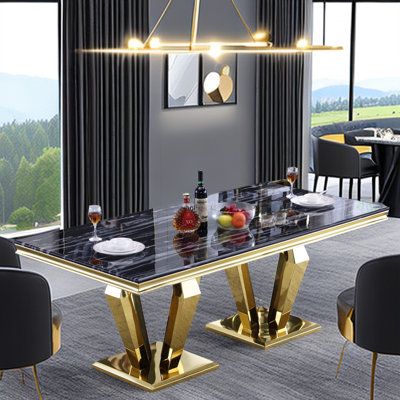 a dining room table with black chairs and gold accents