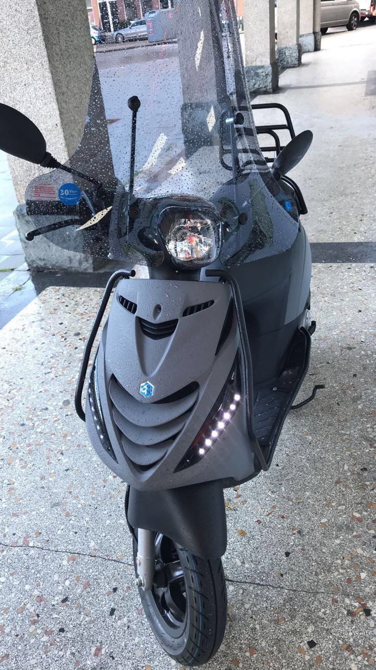 a scooter is parked on the sidewalk in front of a building