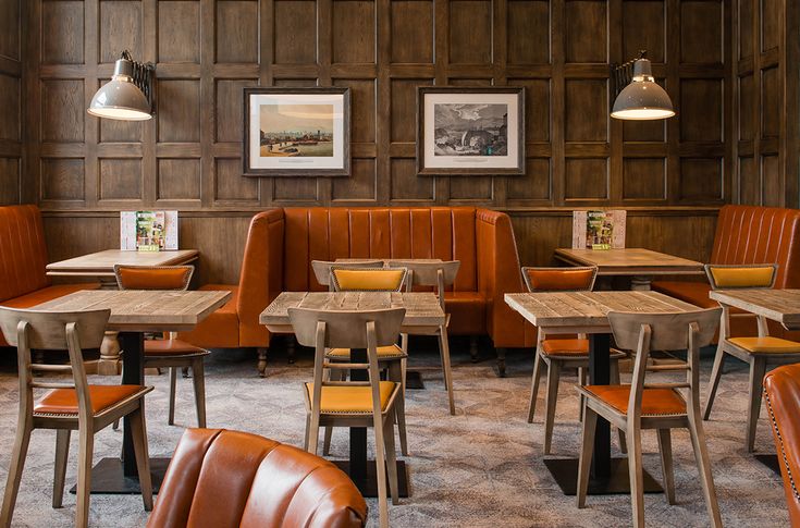 an empty restaurant with leather booths and wooden tables