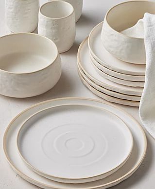 a table topped with white plates and bowls next to napkins on top of each other