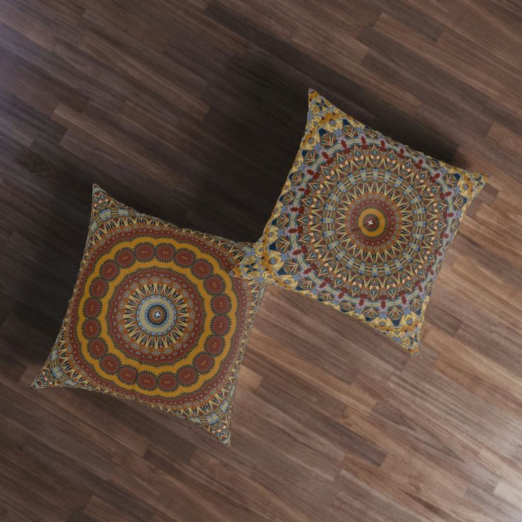 two decorative pillows sitting on top of a wooden floor