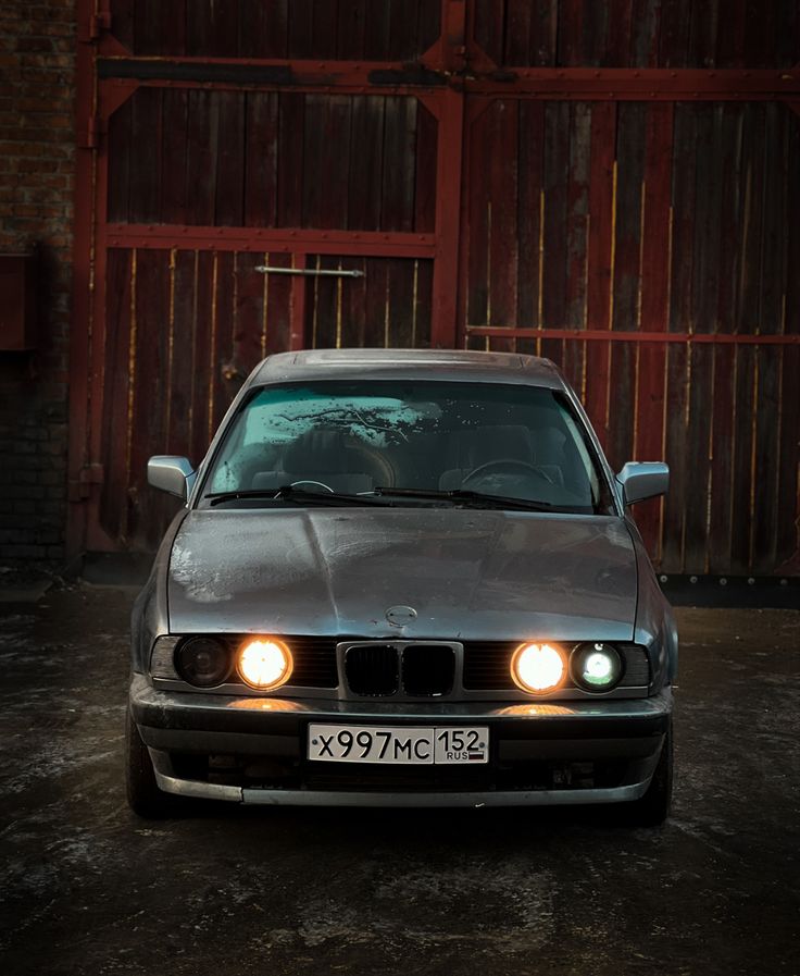 a silver car parked in front of a wooden building