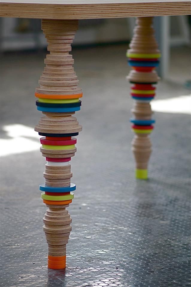 a wooden table topped with lots of different colored pieces of wood stacked on top of each other