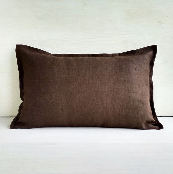 a brown pillow sitting on top of a white bed