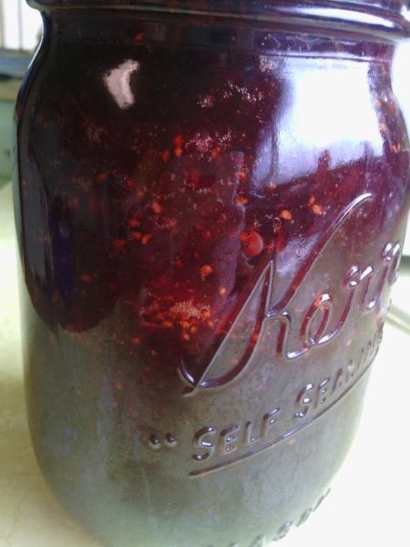 a jar filled with red liquid sitting on top of a counter