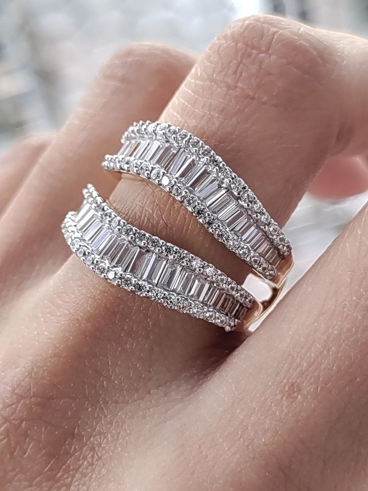 a woman's hand with two diamond rings on it