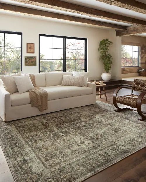 a living room filled with furniture and large windows