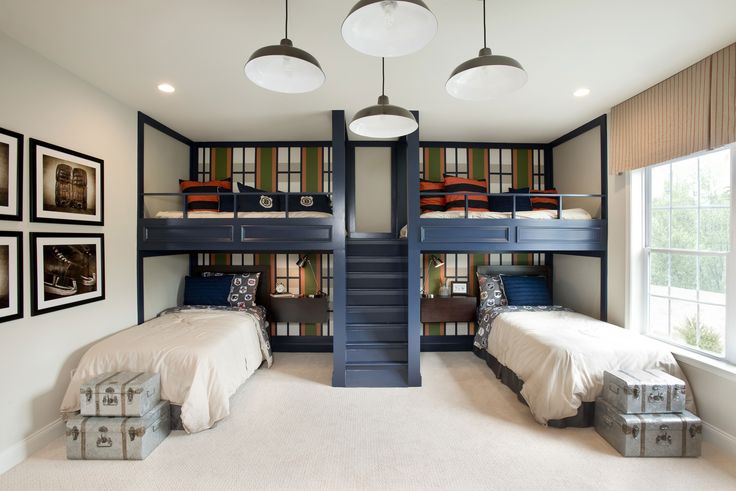 a bedroom with bunk beds and stairs in the middle, along with two lamps hanging from the ceiling