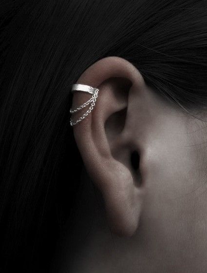 a woman's ear is shown with a pair of earrings on top of it