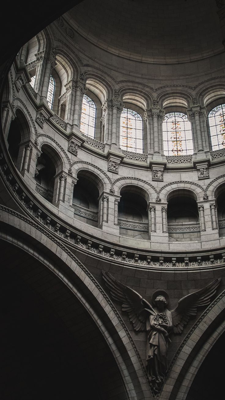 an angel statue is in the middle of a large room with arches and arched windows