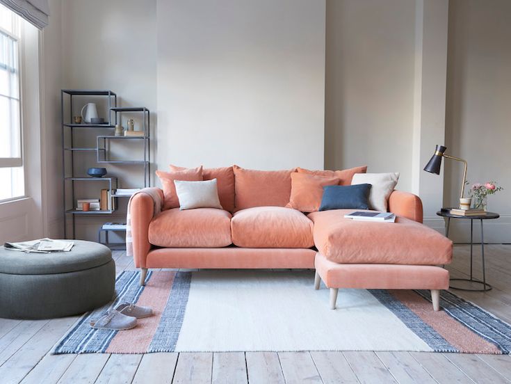 a living room filled with furniture and a rug on top of a hard wood floor