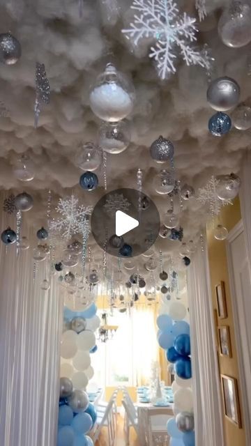 a room filled with balloons and snowflakes hanging from the ceiling