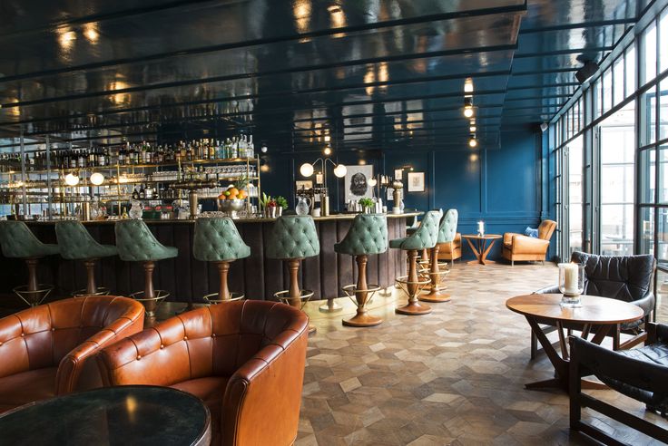 the interior of a restaurant with leather chairs and bar stools