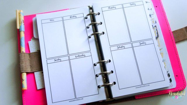 a pink binder with an open planner on it