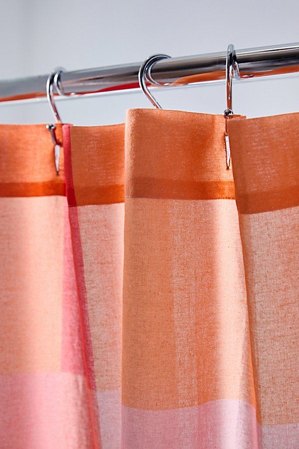 an orange and pink curtain hanging from a metal rod