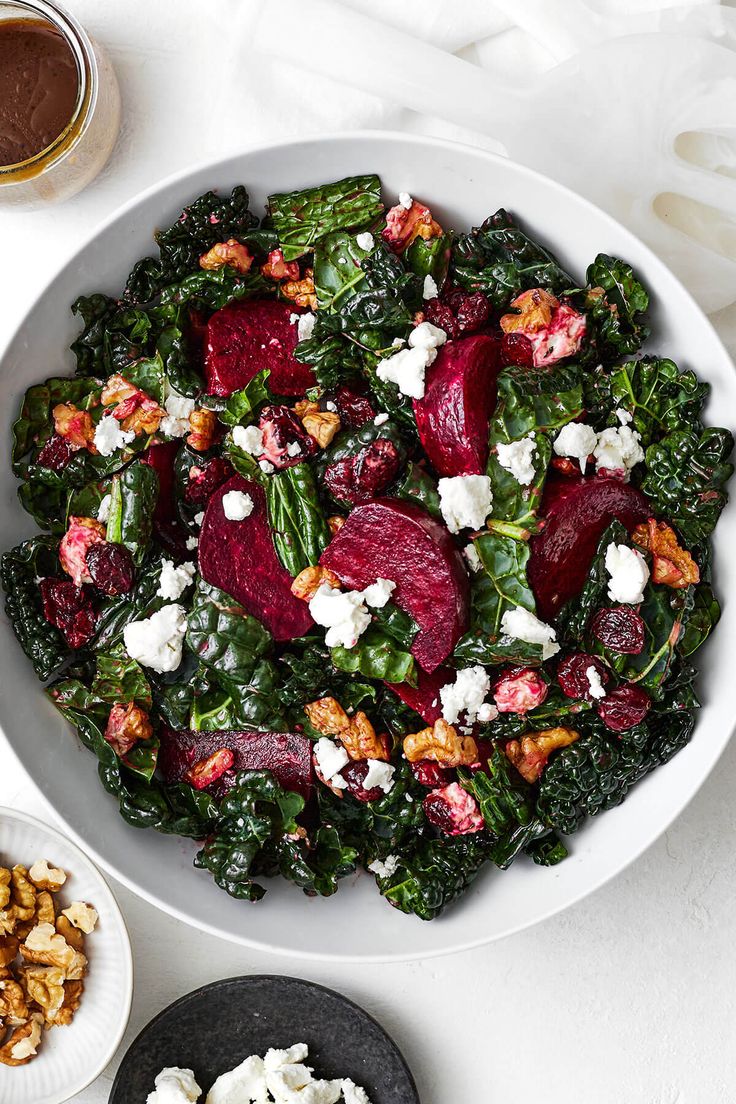 a white bowl filled with beets, feta cheese and walnuts on top of a table