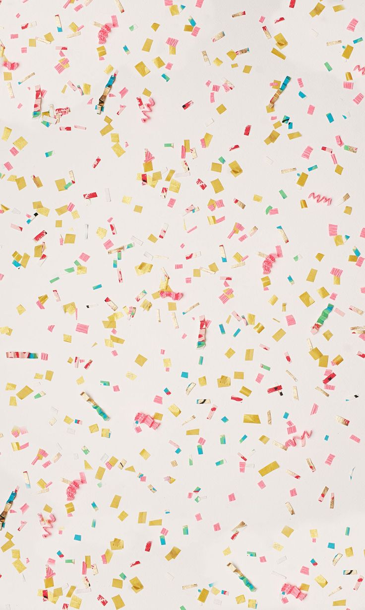 colorful confetti sprinkles are scattered on a white surface with no background