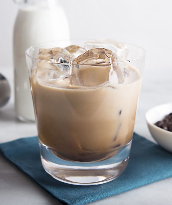 there is a drink with ice in it on the table next to some chocolate chips