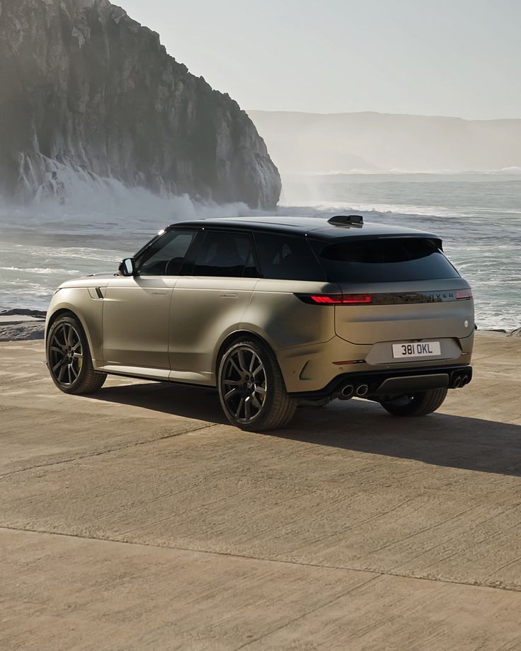 an suv is parked on the beach by the water