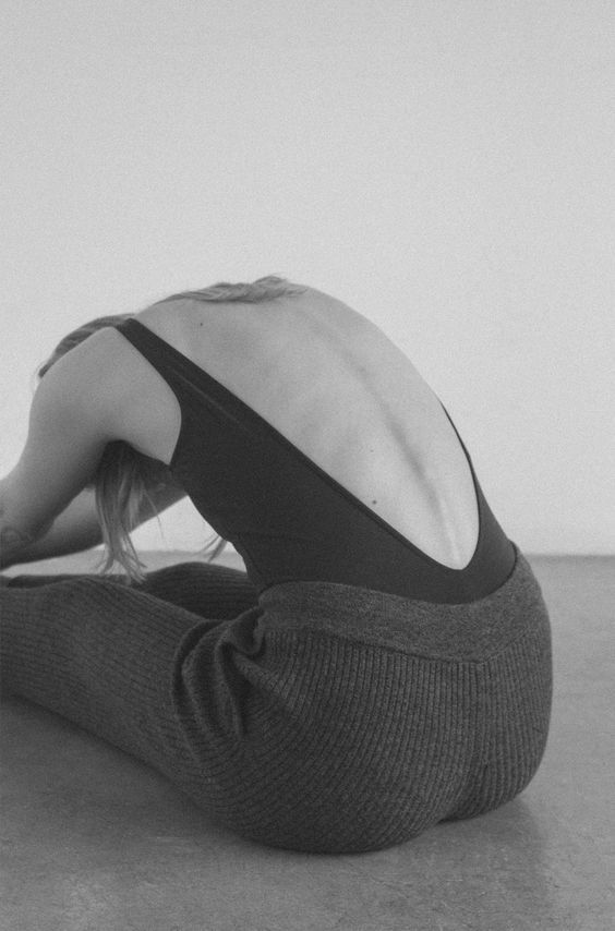 a woman sitting on the floor with her back turned