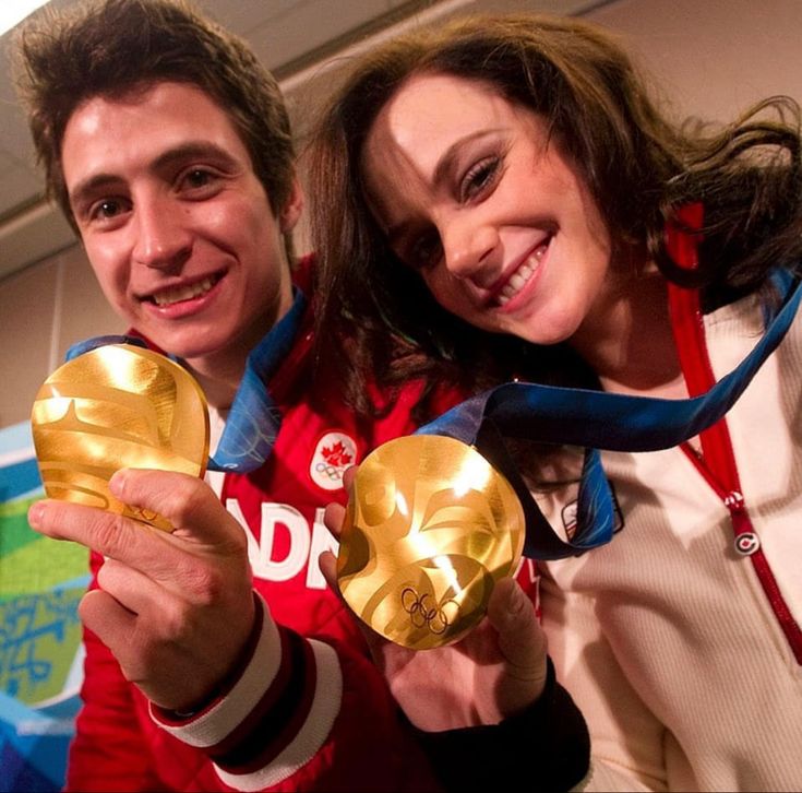 a man and woman holding up two golden trophies