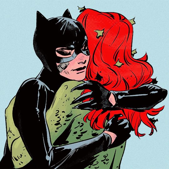 an image of a woman hugging a man in catwoman costume with red hair and black gloves