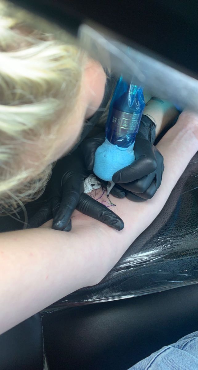 a woman is sitting in the back seat of a car with her arm wrapped around a bottle