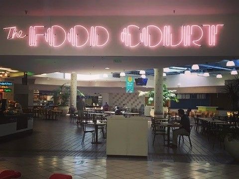 the food court is lit up with neon lights