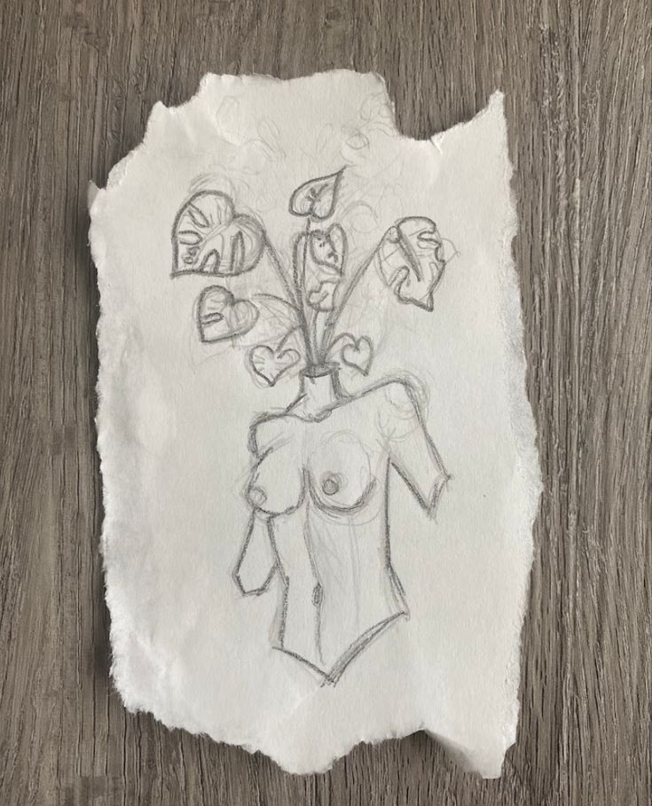 a piece of paper with a drawing of a woman's torso and flowers on it