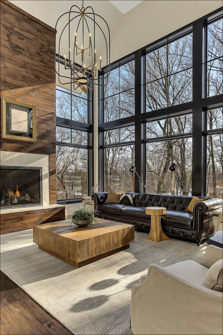 a living room filled with lots of furniture next to large windows and a fire place