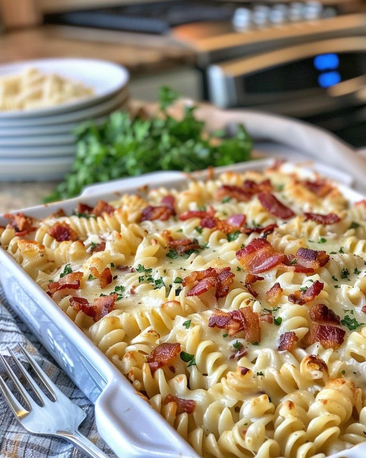 a casserole dish with bacon, cheese and parsley in it on a table