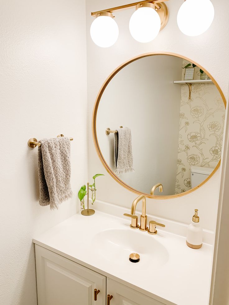 a bathroom with a sink, mirror and towel rack