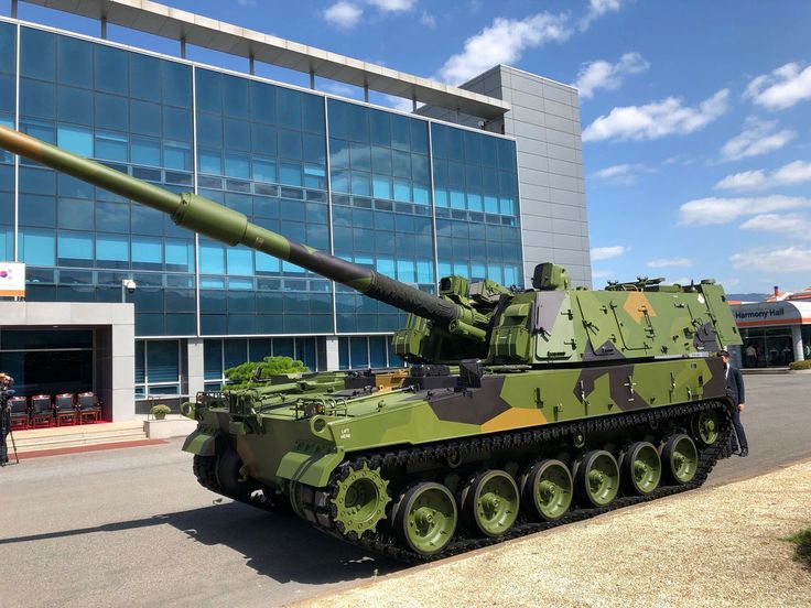 an army tank is parked in front of a building