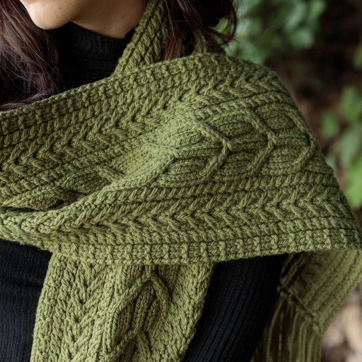 a woman wearing a green knitted scarf