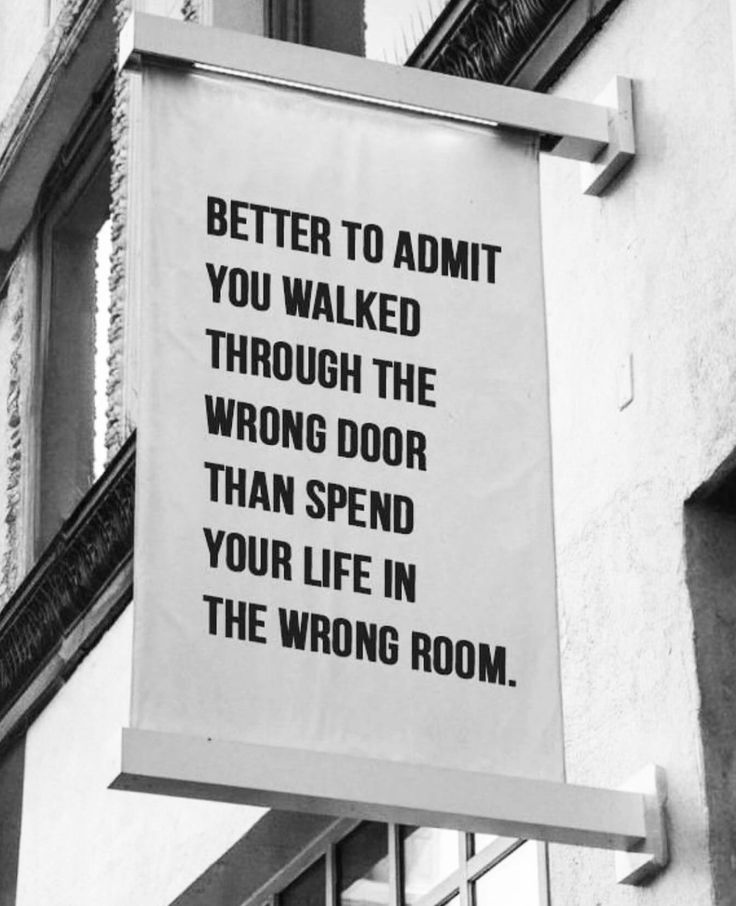 a sign hanging from the side of a building that says, better to admit you walked through the wrong door than spend your life in the wrong room