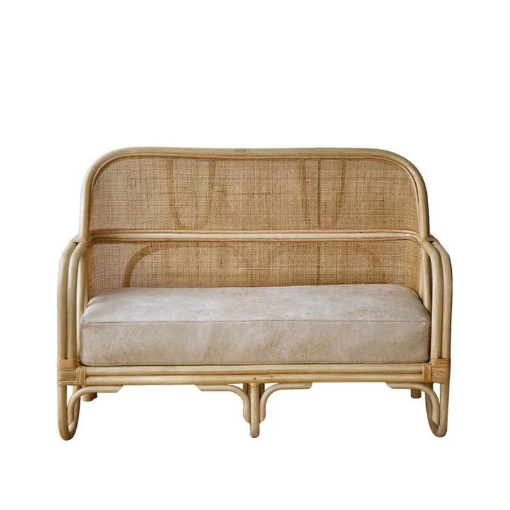 a couch made out of bamboo with a beige upholstered back and seat cushion