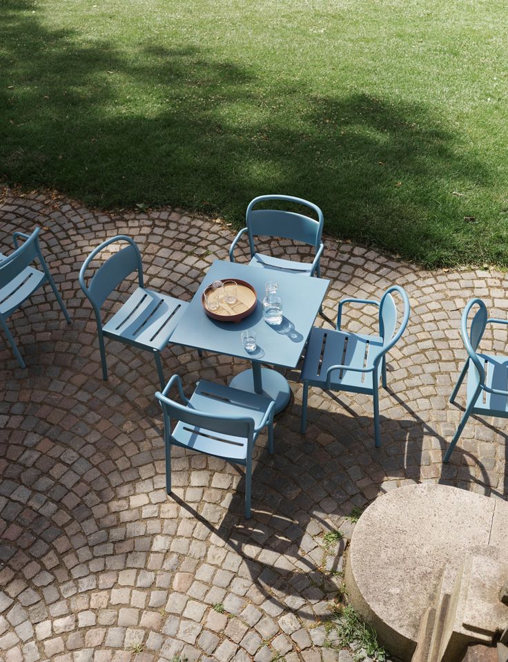 a blue table and chairs sitting on top of a brick patio