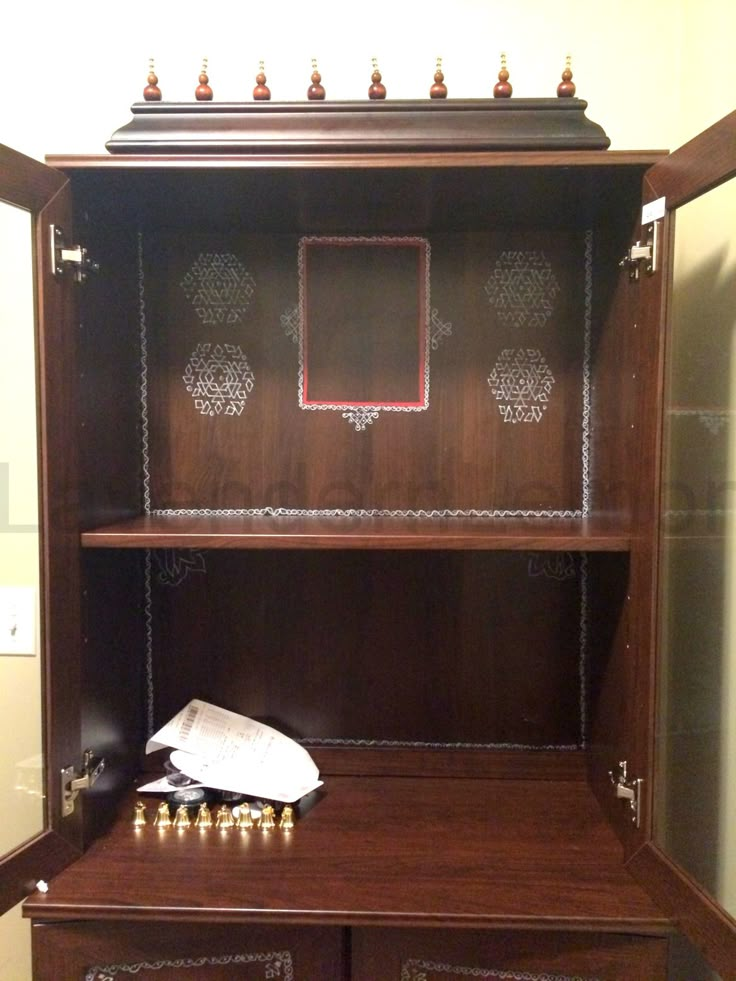 an old fashioned wooden cabinet with candles on it