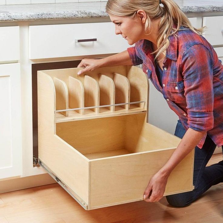 a woman kneeling down in front of an open drawer