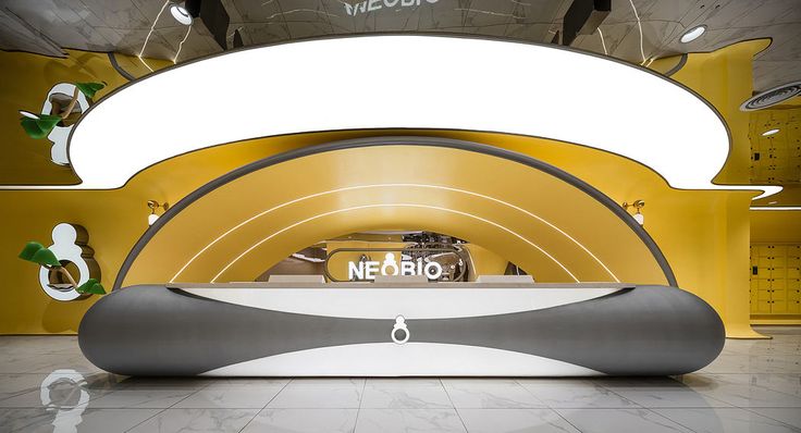 the interior of a car showroom with white and yellow accents, including an oval display