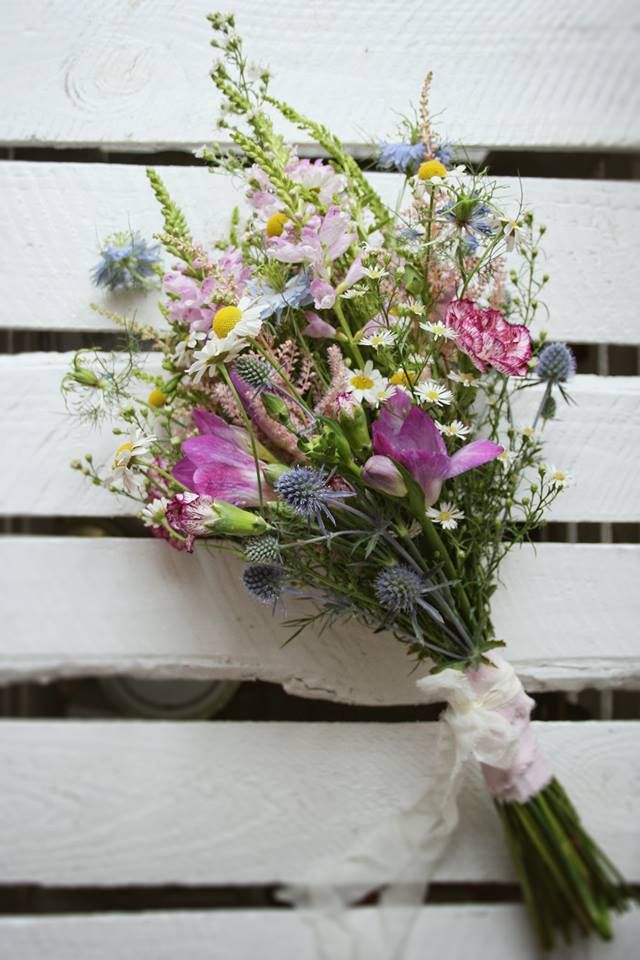 a bouquet of flowers sitting on top of a white bench