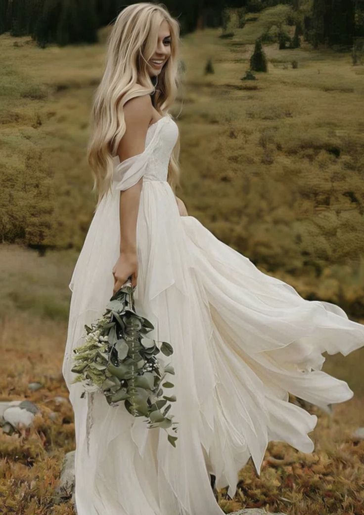 a woman in a white dress is holding a bouquet and walking through the grass with her back to the camera