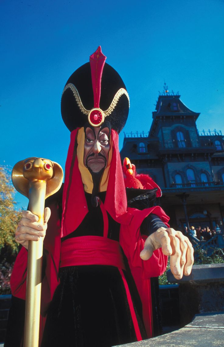 a man dressed in costume holding a large stick