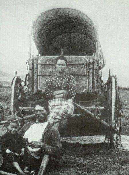 an old black and white photo of people in front of a wagon