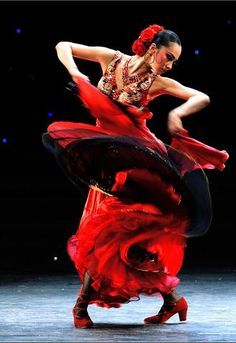 a woman in a red dress is dancing