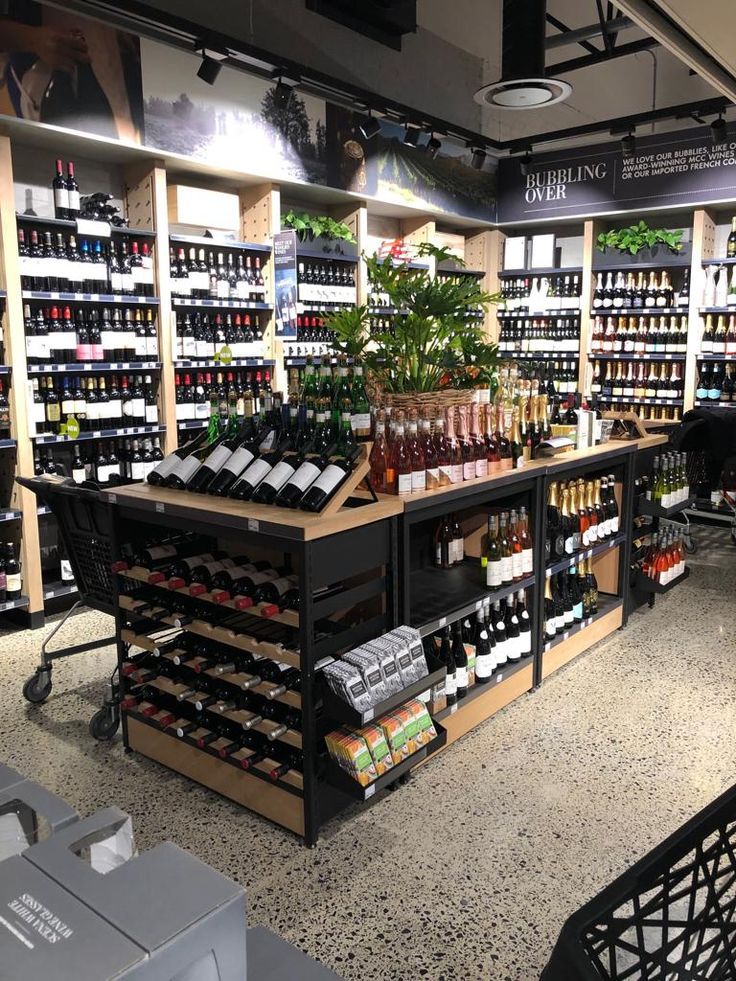 a store filled with lots of bottles of wine and other items on shelves next to each other