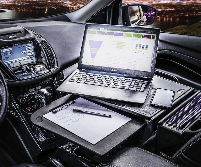 a laptop computer sitting on top of a desk next to a pen and paper holder